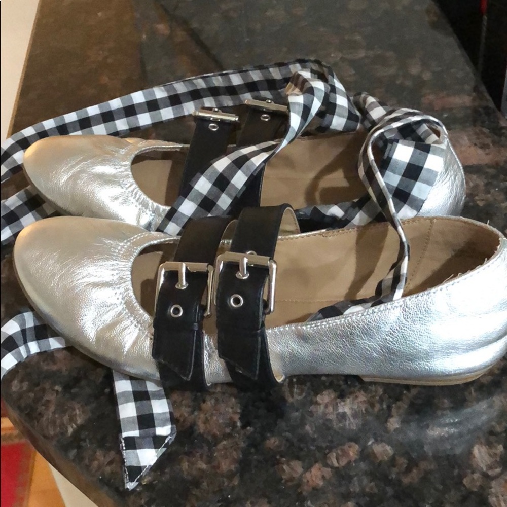 Flat silver shoes, ties around ankle.